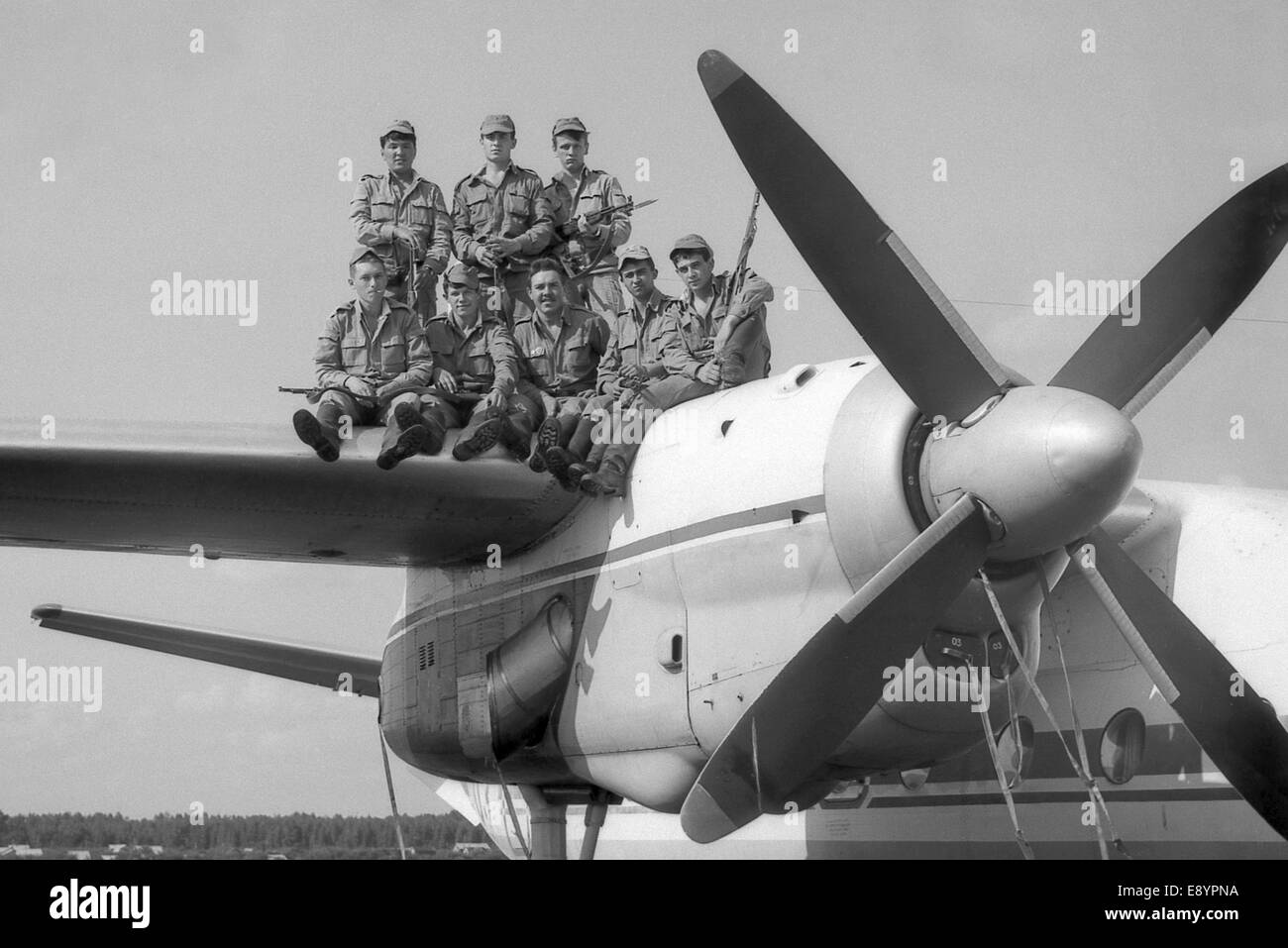 A group of soldiers standing on the wing of a military transport aircraft AN-24. Film scan. Stock Photo