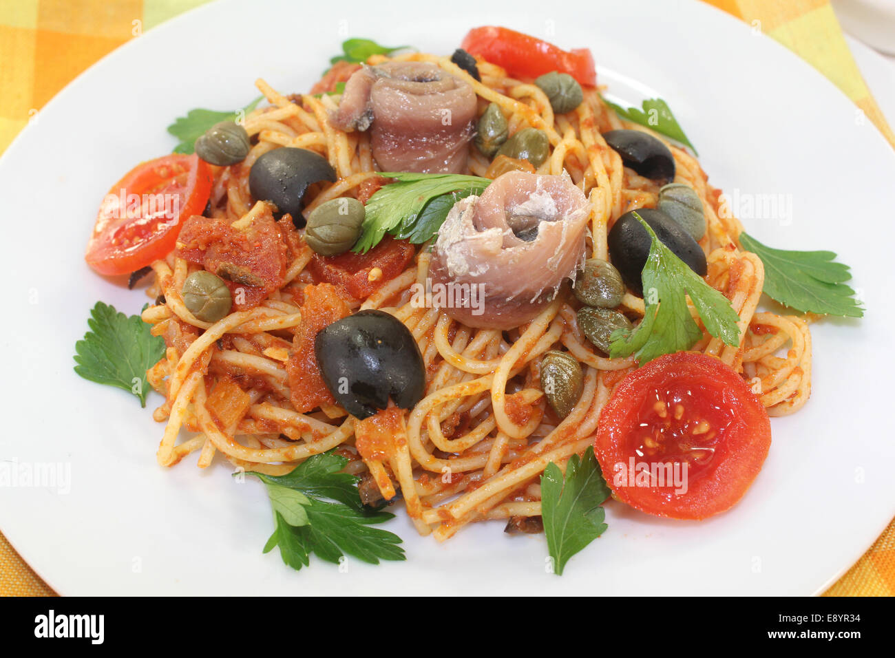 Capellini with tomatoes, anchovies, capers and olives Stock Photo