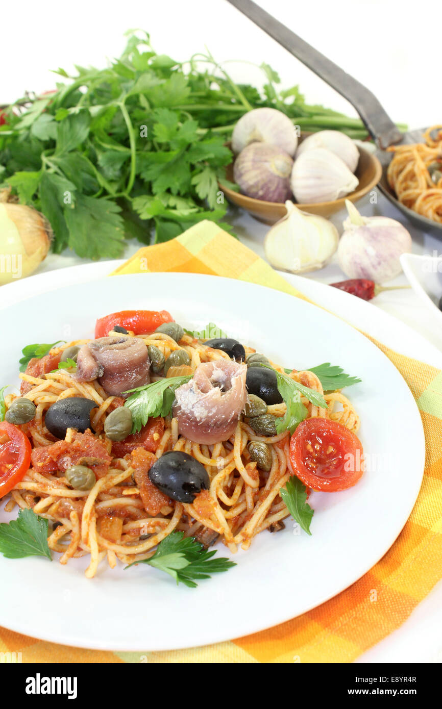 Capellini with tomatoes, anchovies, capers and olives Stock Photo