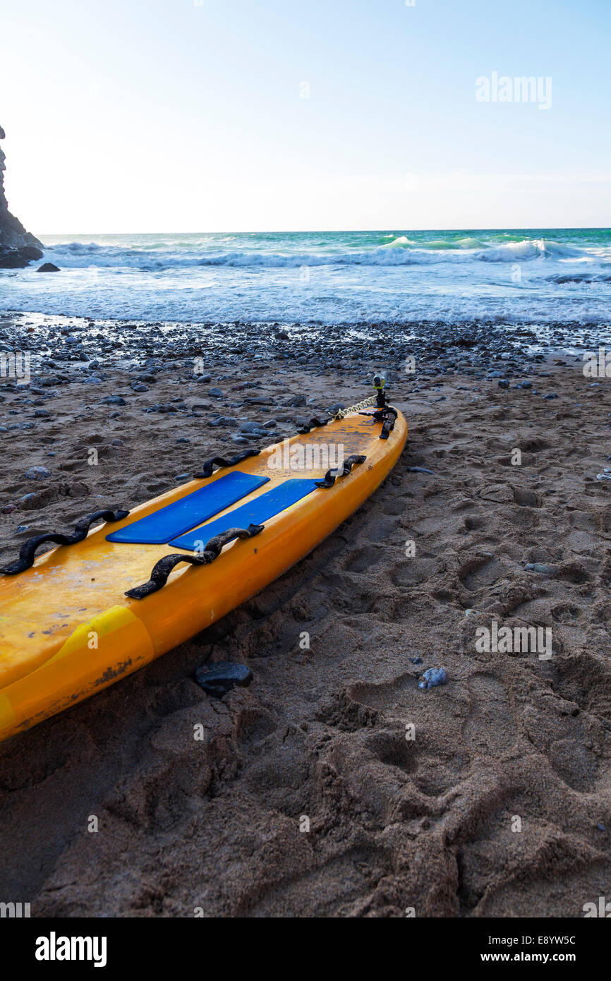 paddle board RNLI lifeguard life saving raft on beach in Cornwall UK