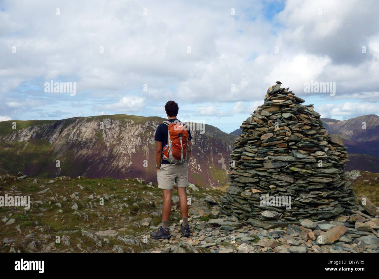 A hill walker at a  cairn in the Lake District Stock Photo