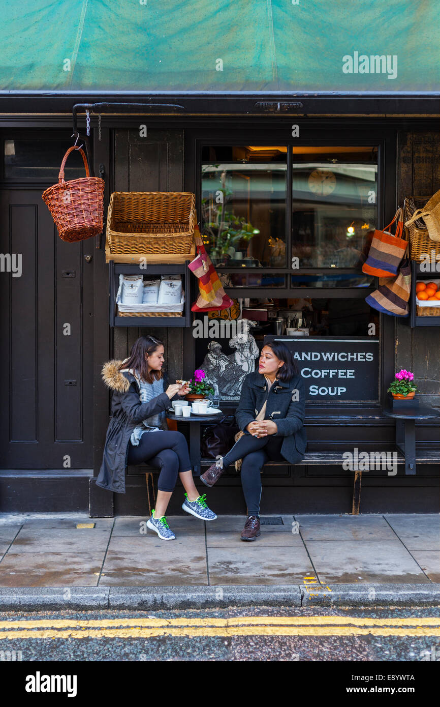 Two Ladies Taking Refreshments on Pavement Outside Cafe Stock Photo