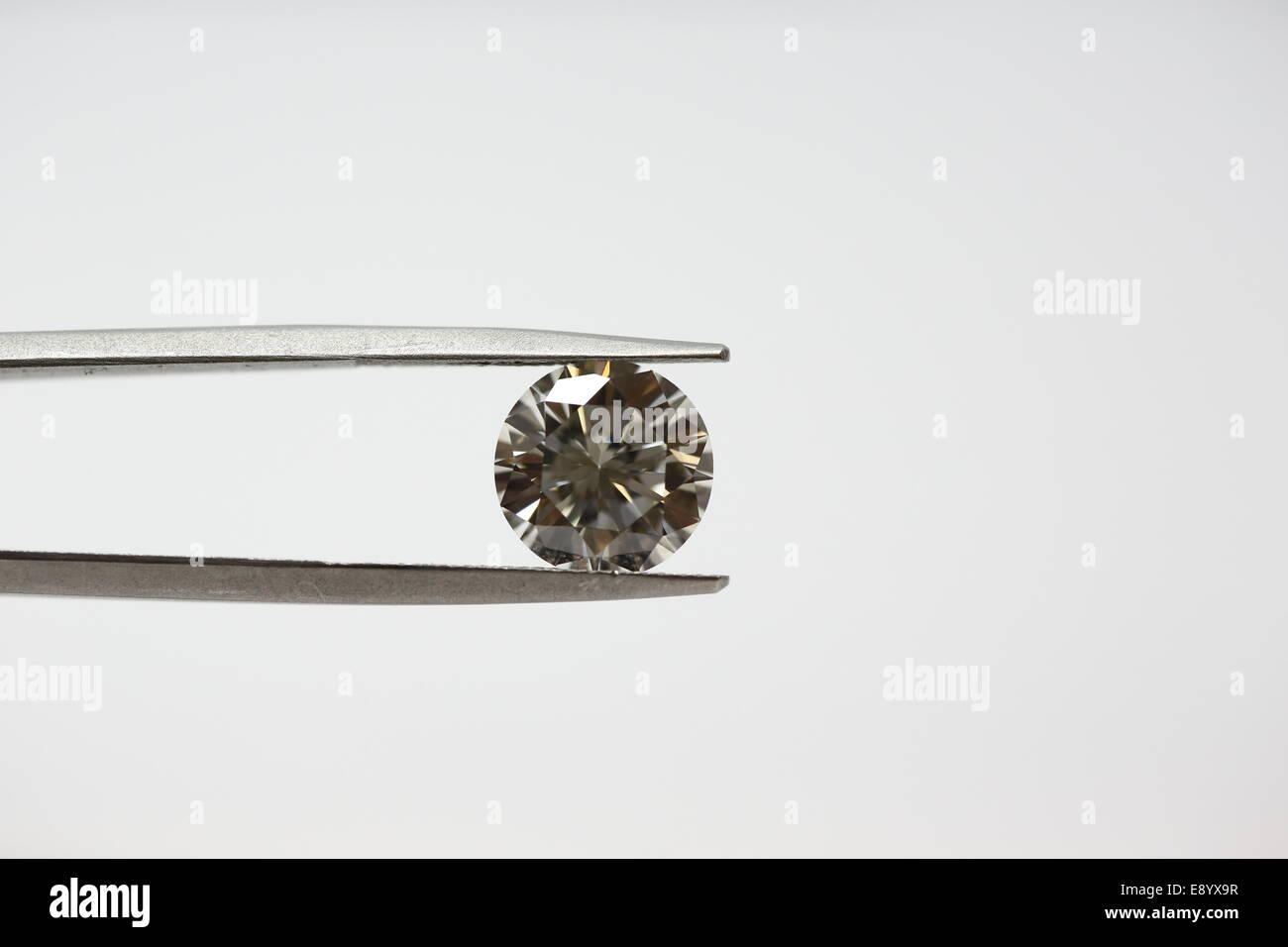 4.02 carat Round Brilliant cut loose diamond holds with tweezers Stock Photo