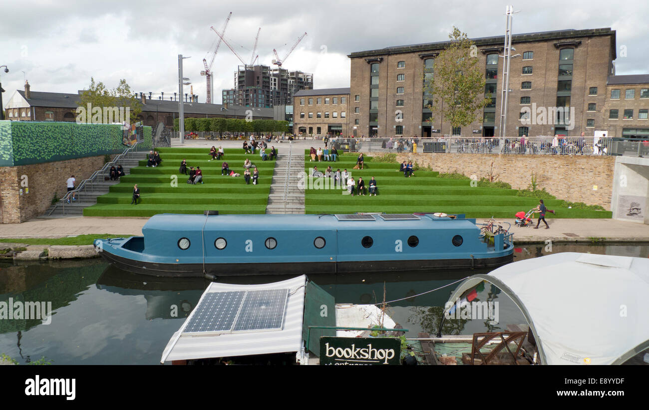 London UK. 16th October 2014. On a warm autumn afternoon people eat lunch from street food vans on the astroturf steps outside UAL University of the Arts in Kings Cross by Regents canal.  KATHY DEWITT/Alamy Live News Stock Photo