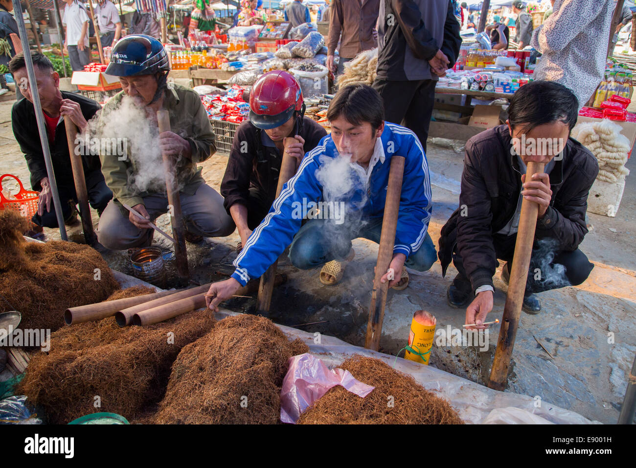Vietnamese Hill Tribe Hmong men at Can Cau Market smoking tobacco in bamboo pipes Stock Photo