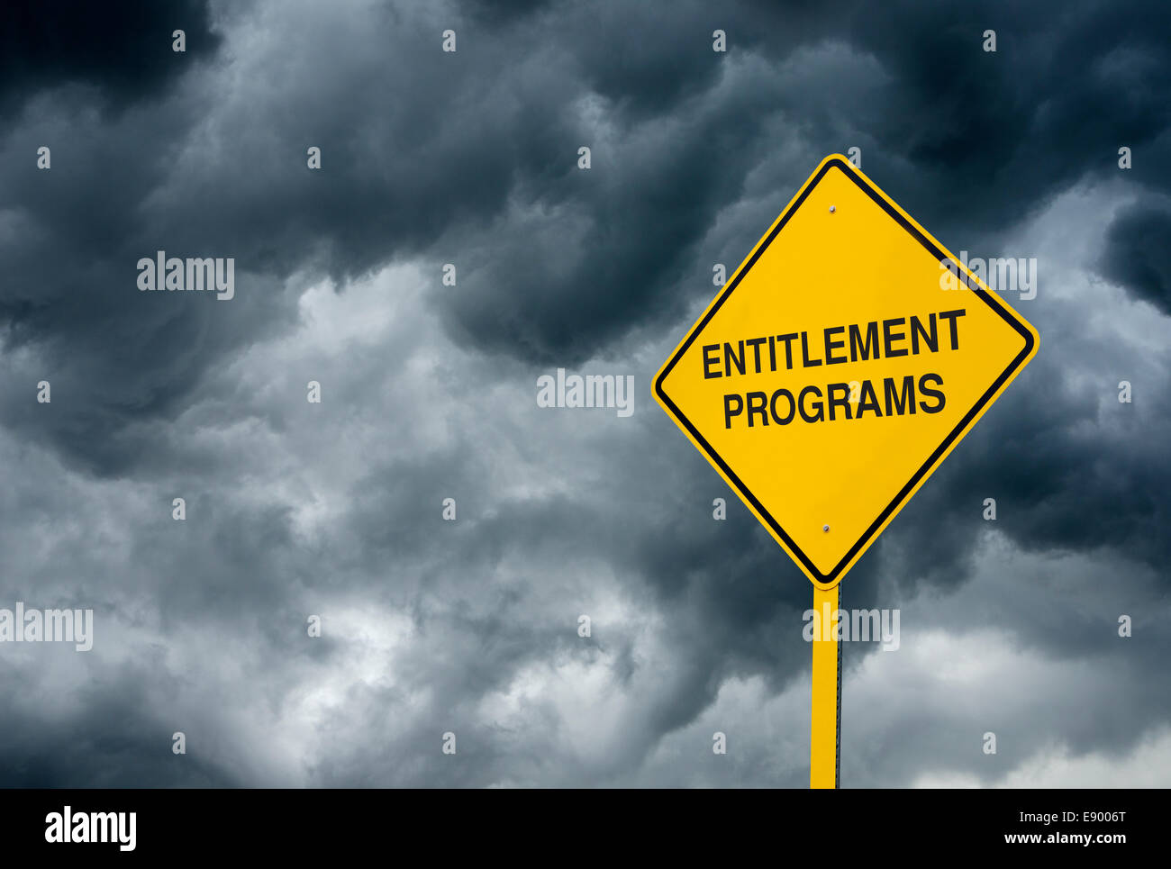 A Caution Sign in front of storm clouds warning of 'Danger Entitlements Programs.' Stock Photo