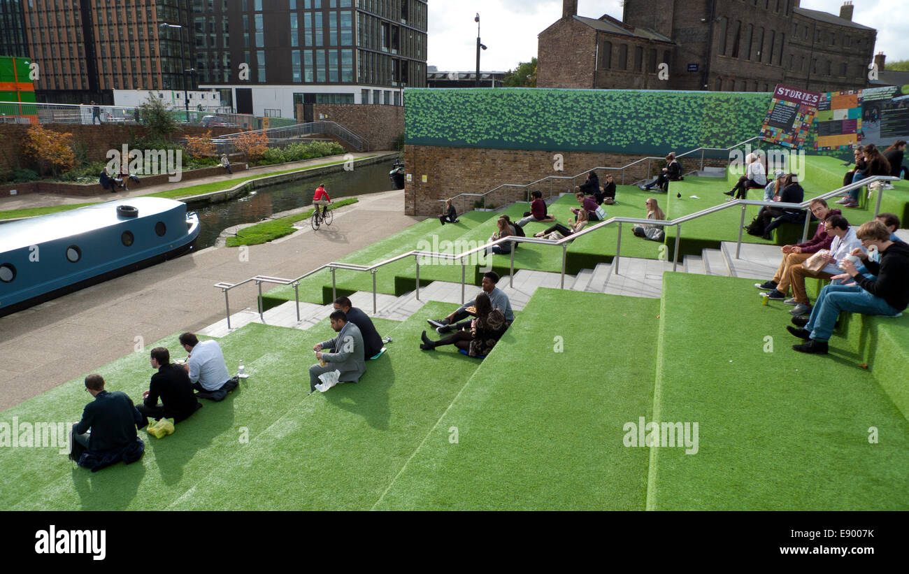 London UK. 16th October 2014. On a warm autumn afternoon people eat lunch from street food vans on the astroturf steps outside UAL University of the Arts in Kings Cross by Regents canal.  KATHY DEWITT/Alamy Live News Stock Photo