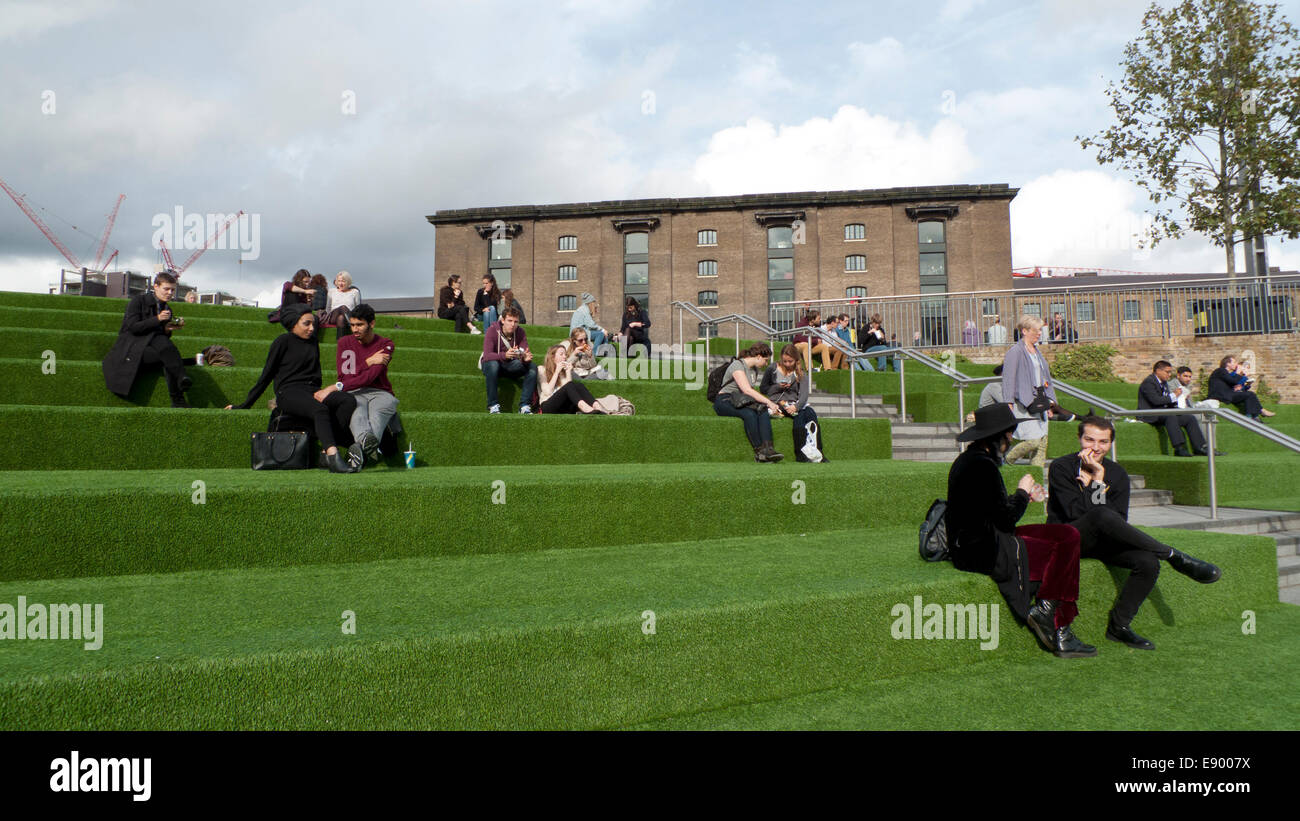 People sitting on green astro turf terrace outside UAL University of the Arts in Kings Cross by the Regents Canal London UK  KATHY DEWITT Stock Photo