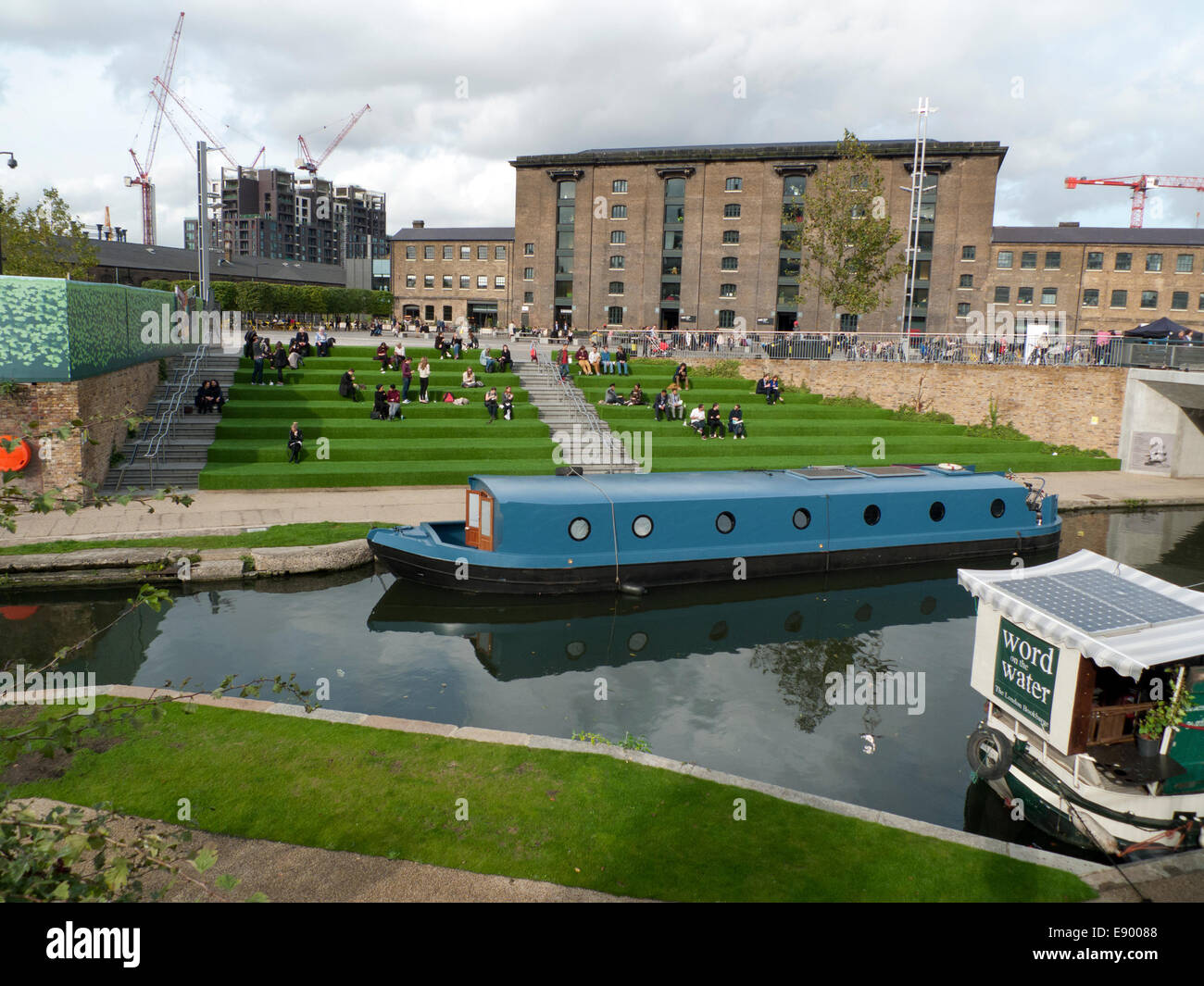 London UK. 16th October 2014. On a warm autumn afternoon people eat lunch from street food vans on the astroturf steps outside UAL University of the Arts in Kings Cross by Regents canal. KATHY DEWITT/Alamy Live News Stock Photo