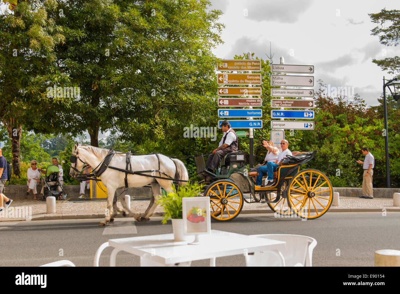 Portugal Sintra tourist white horse & carriage droschke by road street sign signpost by cafe table Stock Photo