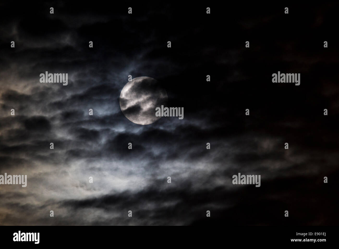 A big moon in a cloudy sky on a dark night Stock Photo