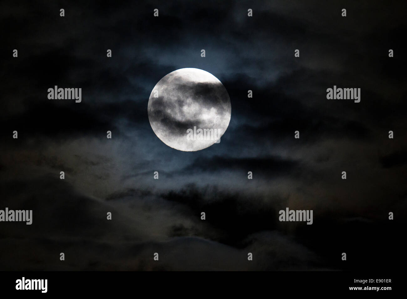 A big moon in a cloudy sky on a dark night Stock Photo