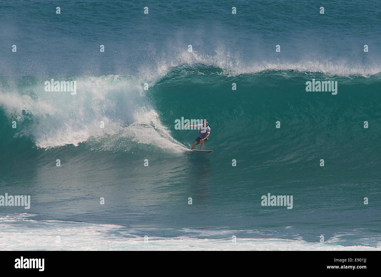 Surf board rider on catching large wave Ulu Watu Bali Indonesia Stock Photo