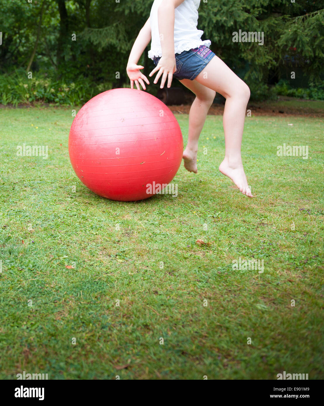 Child on a space hopper in a garden Stock Photo