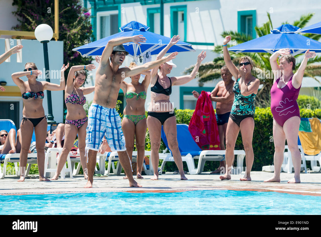 Holiday entertainer and hotel guests exercising a the swimming pool, Mastichari, Kos, Greece Stock Photo