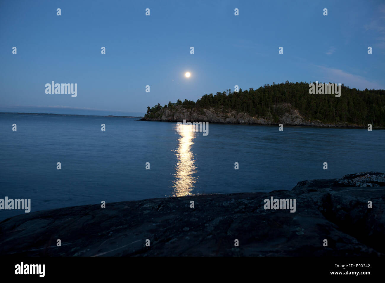 The moon reflecting in a beautiful blue sea Stock Photo
