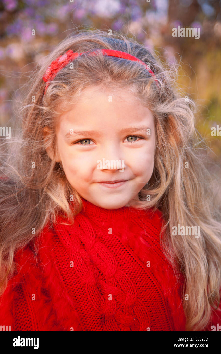 Girl in a red poncho on a background of autumn landscape Stock Photo