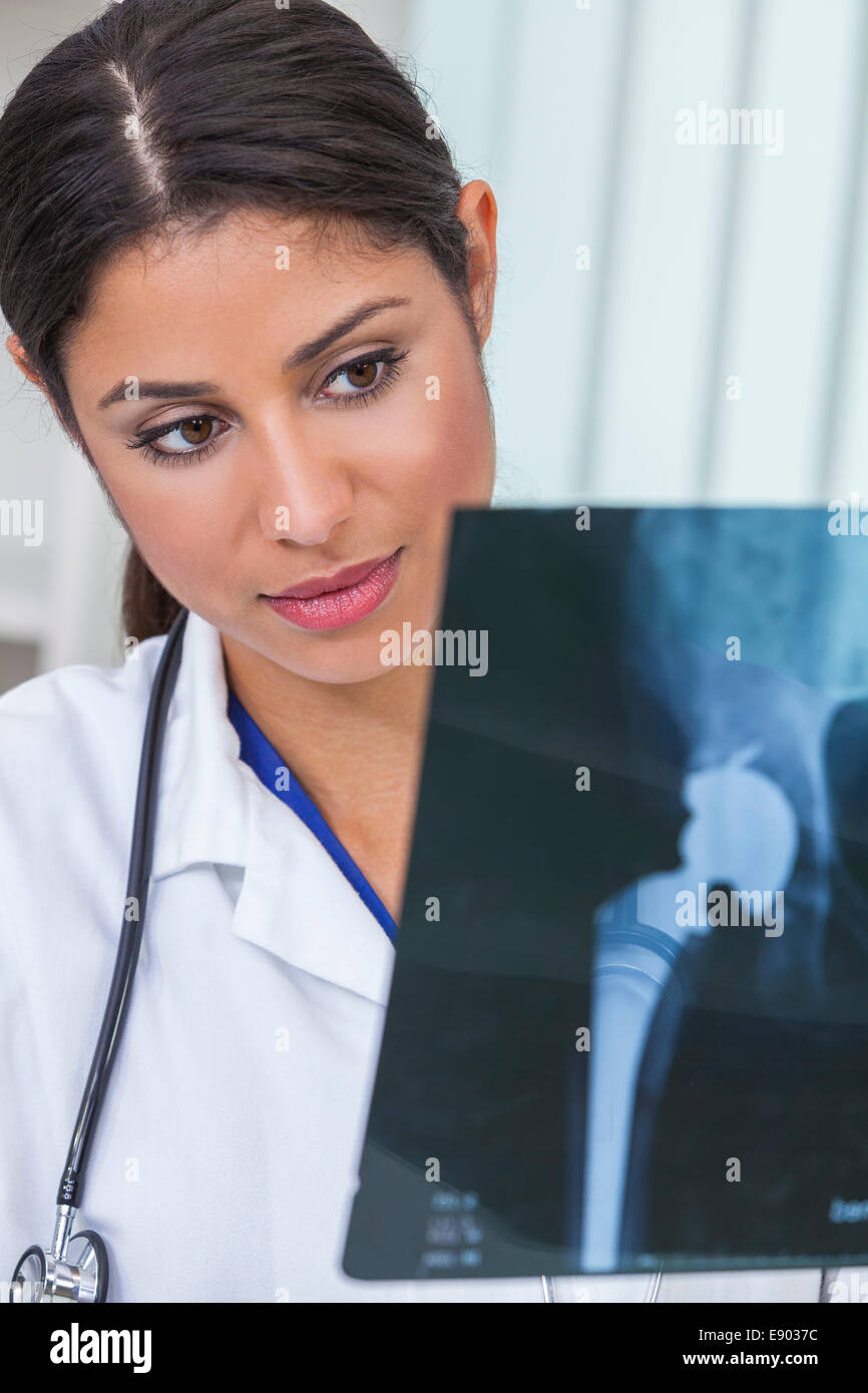 A Latina Hispanic female medical doctor surgeon looking at hip replacement x-ray in a hospital Stock Photo
