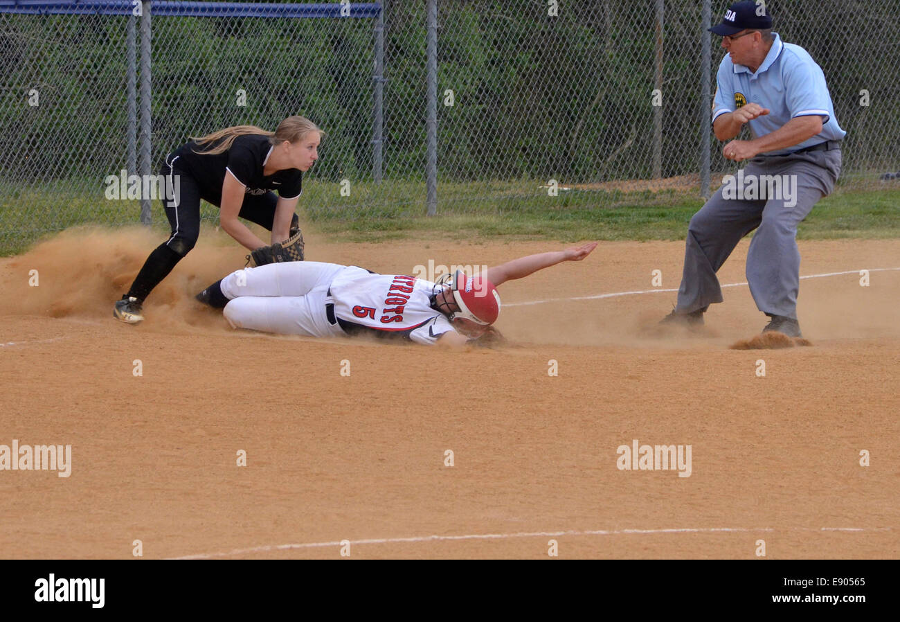 Runner  sliding onto  base in a softball game Stock Photo