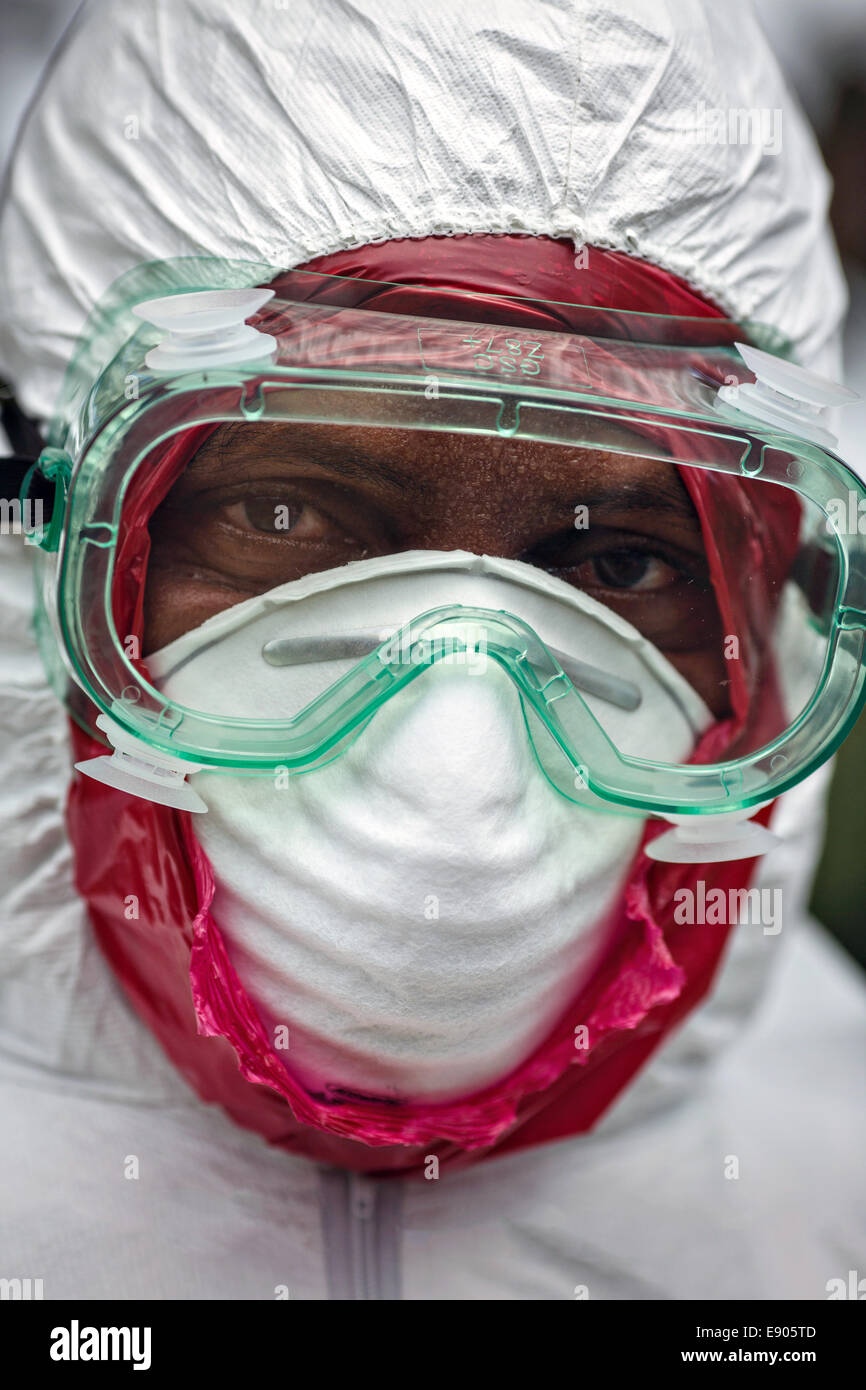 Healthcare volunteer dress in protective clothing as they prepare to remove the corpse of an