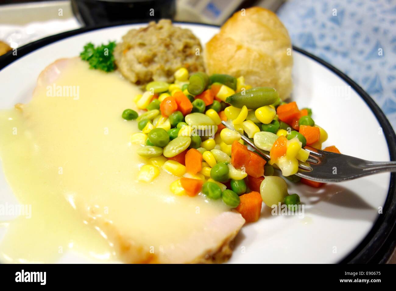 Hospital meal of turkey and stuffing with gravy, roll and corn, pea, carrot, bean medley. Stock Photo