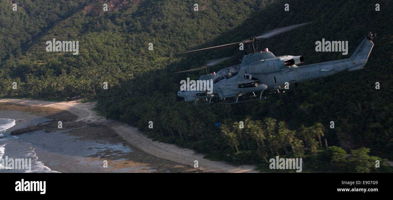 Two U.S. Marine Corps AH-1W Super Cobra helicopters assigned to Marine Medium Tiltrotor Squadron (VMM) 262 (Reinforced), 31st Marine Expeditionary Unit fly in a tight formation over Clark Air Base, Pampanga province, Philippines, Sept. 30, 2014, during Am Stock Photo