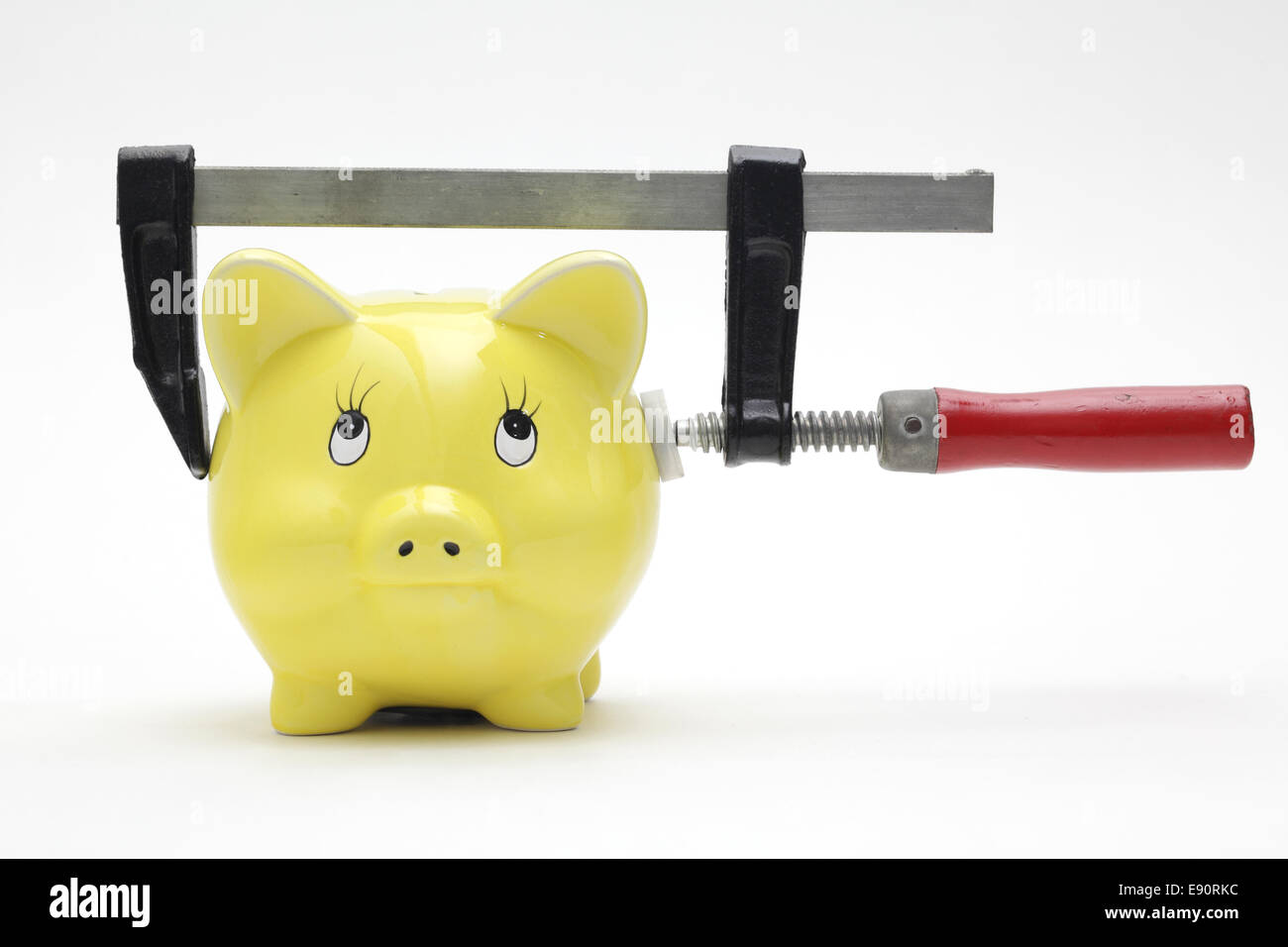 Piggy bank squeezed in a clamp Stock Photo