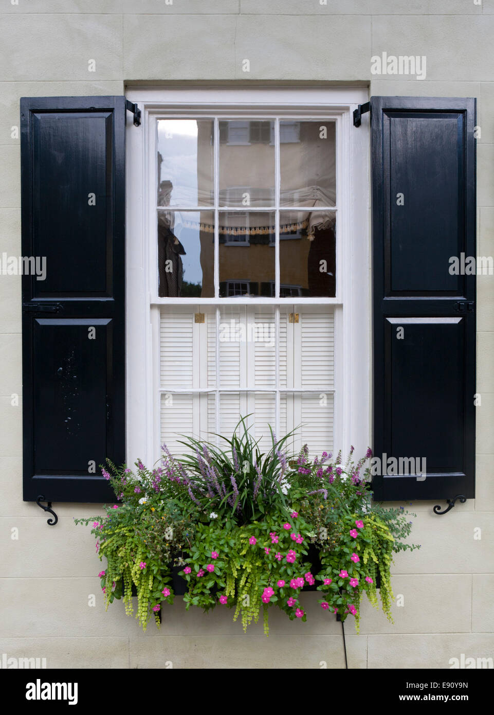 Window, shutters and flower box on a house in historic downtown Charleston, South Carolina. Stock Photo