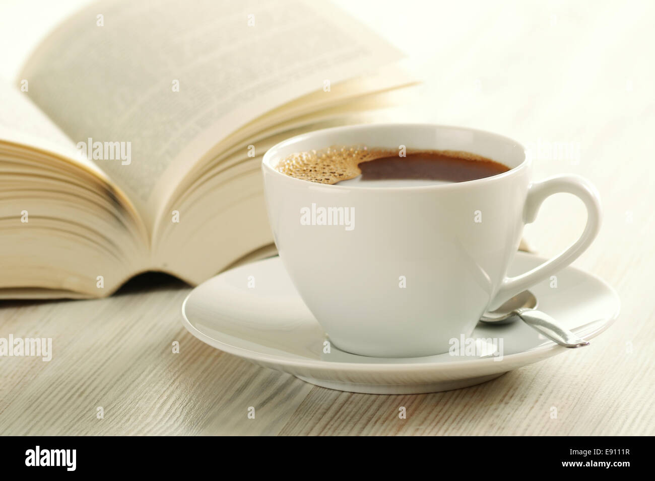 Cup of coffee and open book on the table Stock Photo - Alamy