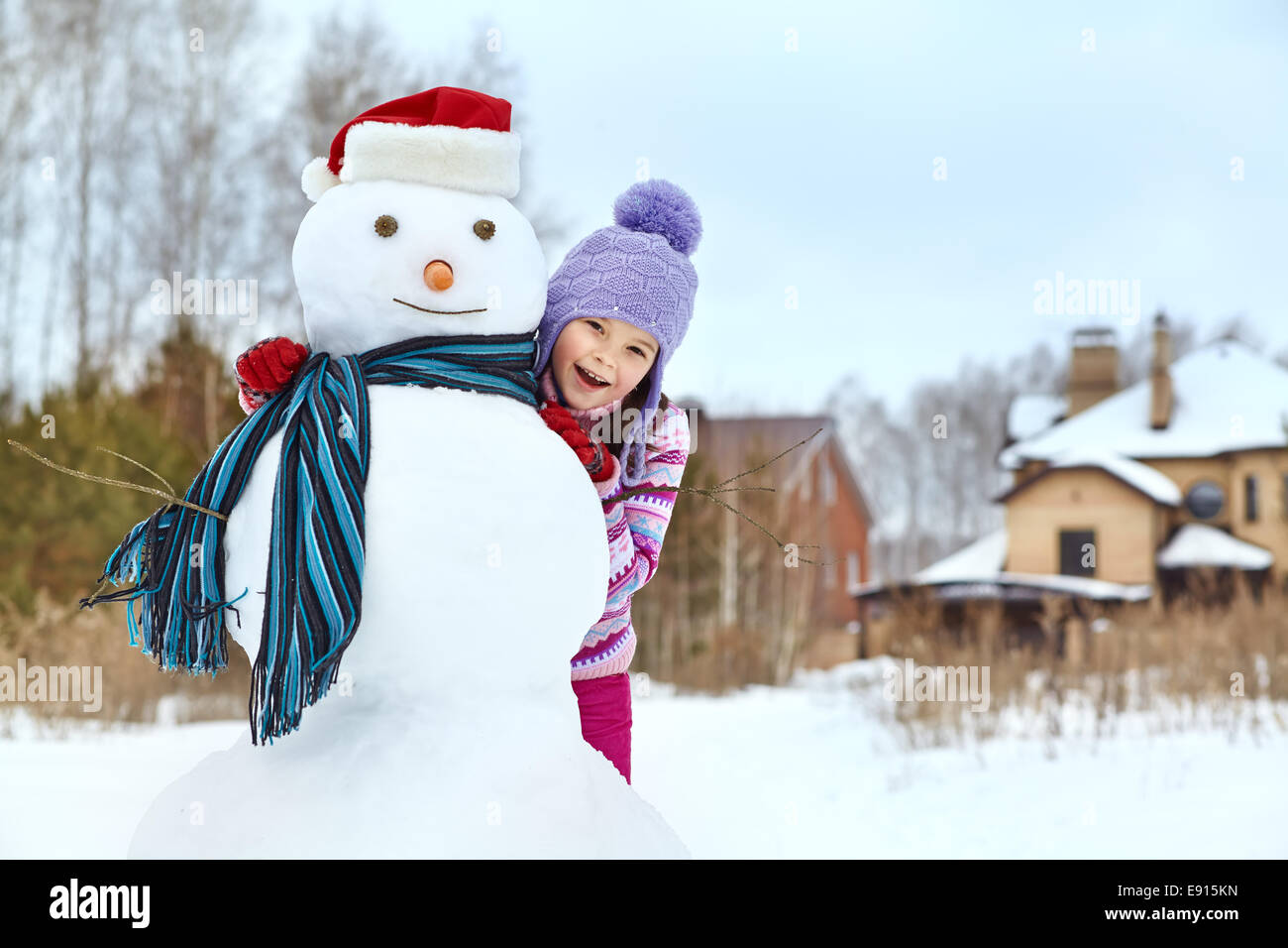 kid playing with snowman Stock Photo