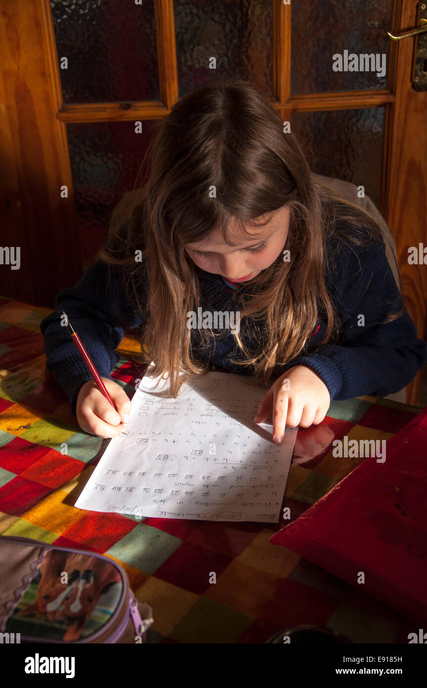 Seven year old Irish girl doing homework on kitchen table in Donegal Ireland Stock Photo