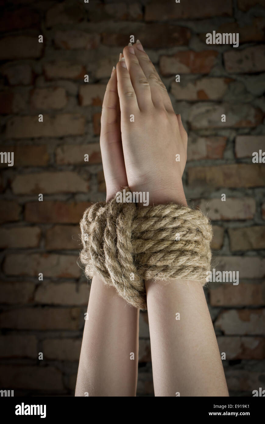Hands tied up with rope Stock Photo