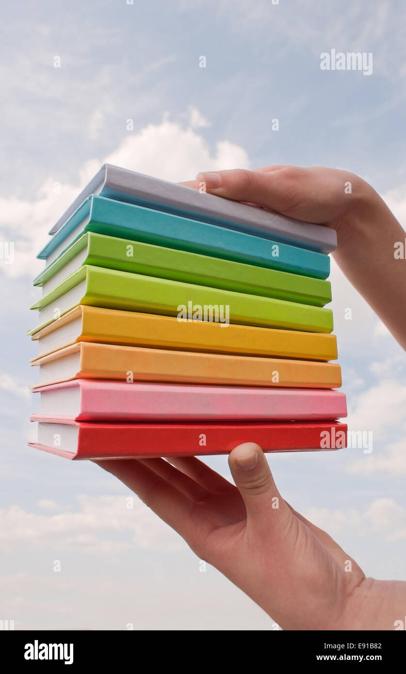 Hands holding color hard cover books Stock Photo