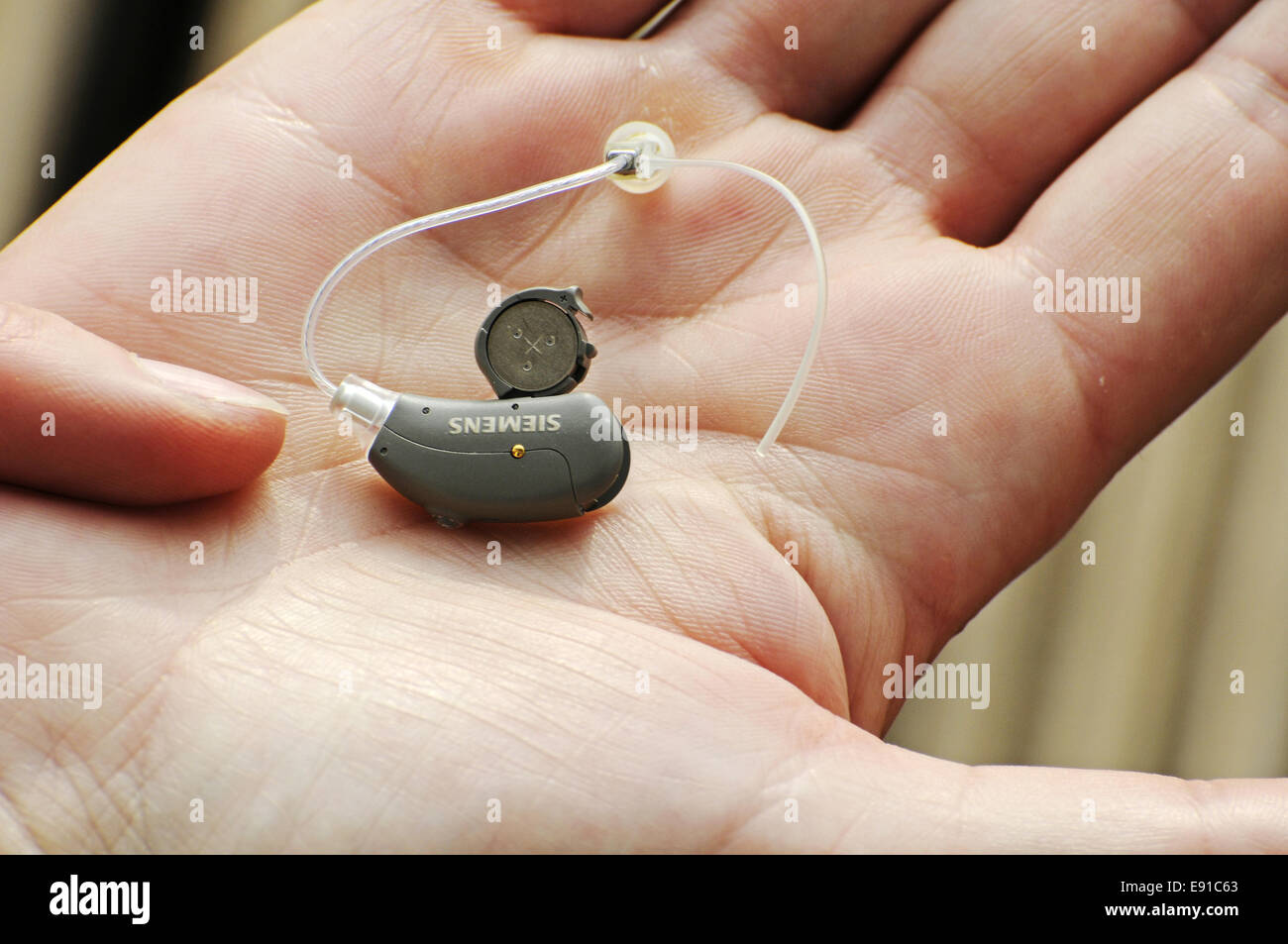 Modern small hearing aid in the palm of a woman Stock Photo Alamy