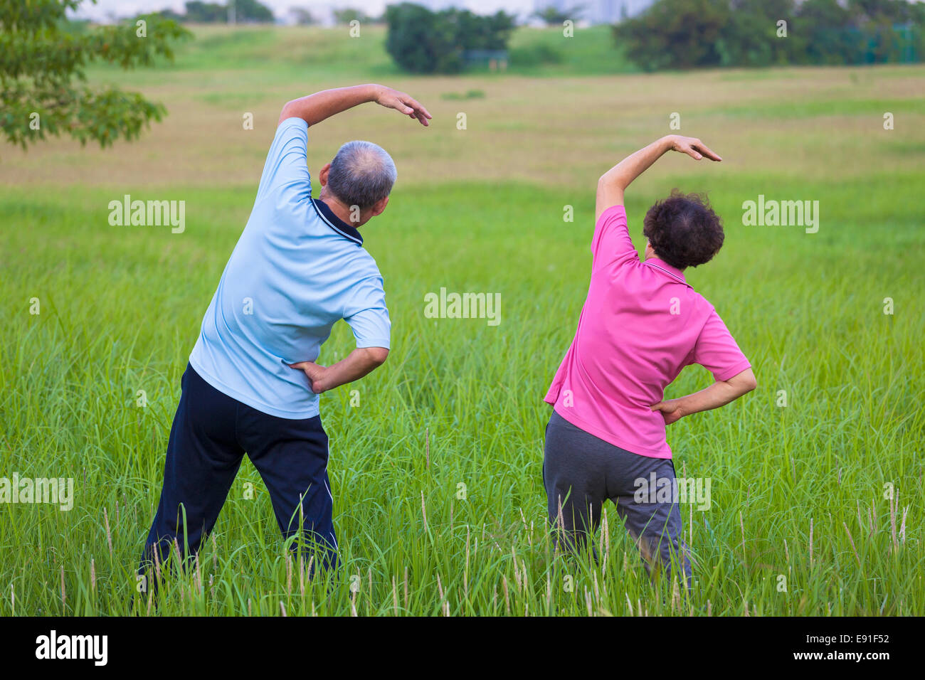 rear view of Senior couple doing gymnastics in the park.healthy concept ...