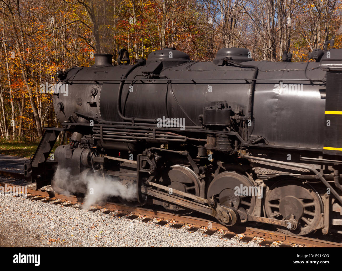 Steam train powers along railway Stock Photo