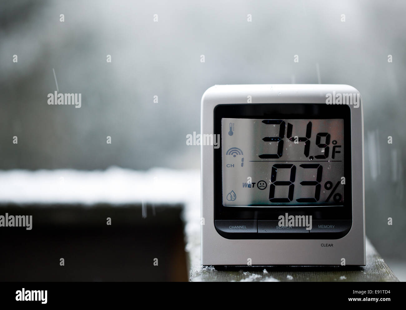 Snow falling behind thermometer Stock Photo