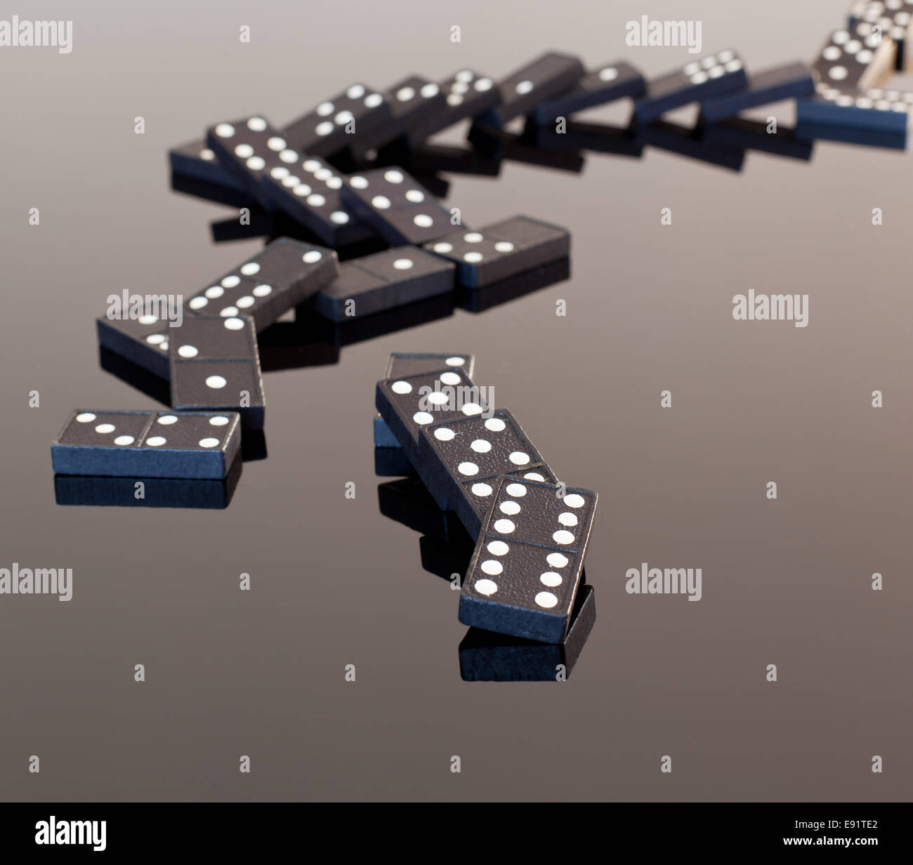 Dominoes collapsed on reflective surface Stock Photo