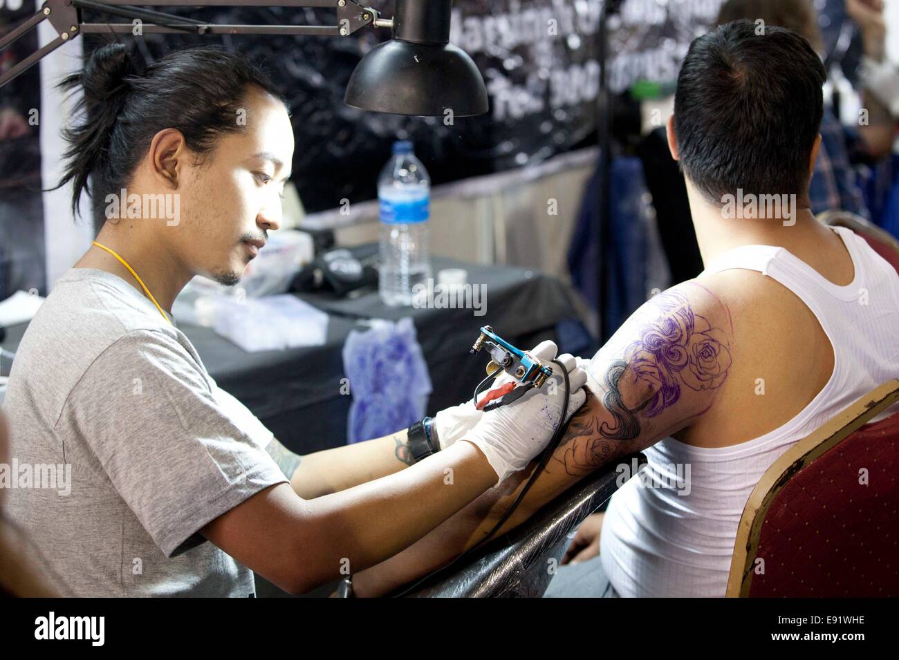 Kathmandu, Nepal. 17th Oct, 2014. A tattoo artist draws tattoo to a