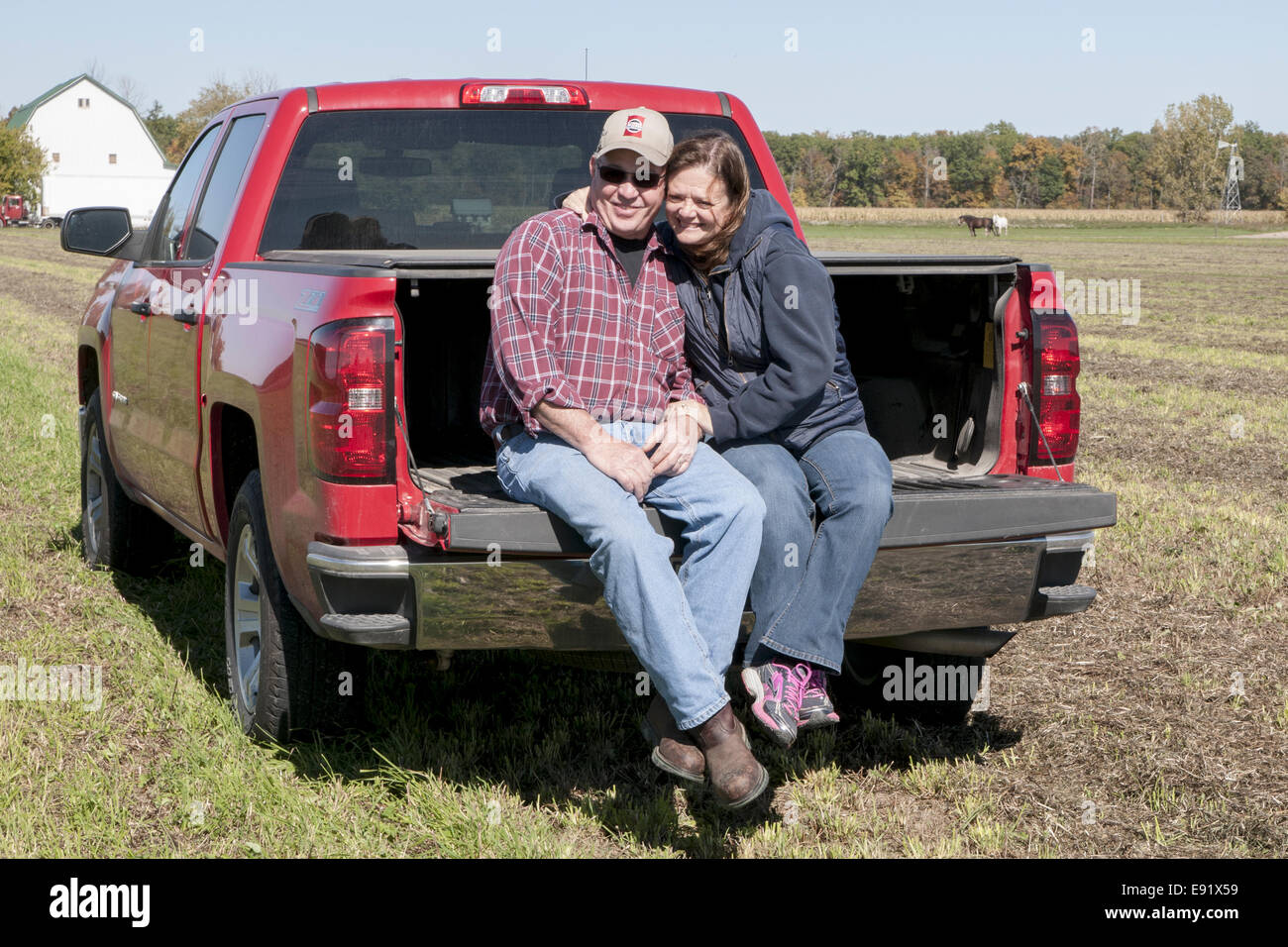 Mature couple sitting on tail gate of truck Stock Photo Alamy