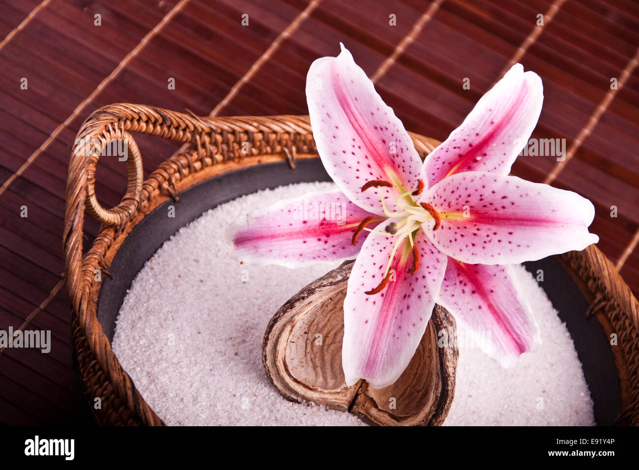 Bowl with sand and pink lily Stock Photo