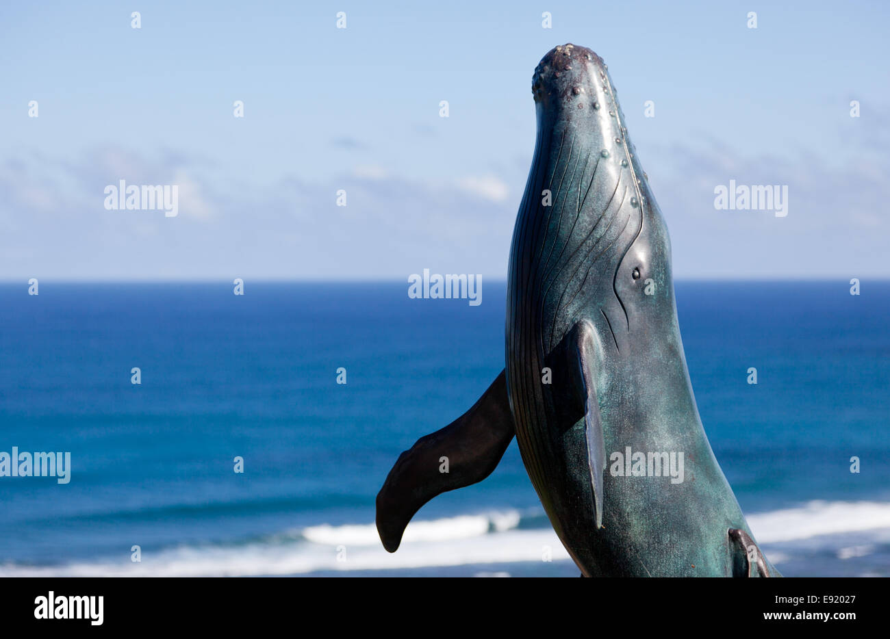 Statue of whale breaching with sea Stock Photo