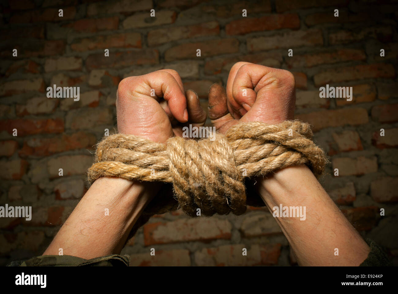 Hands of man tied up with rope Stock Photo