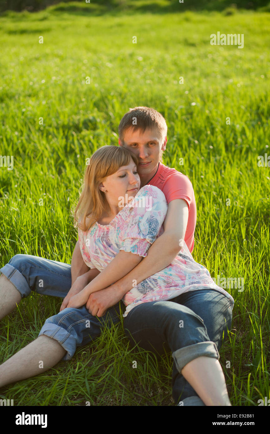 Happy couple lying on grass Stock Photo - Alamy