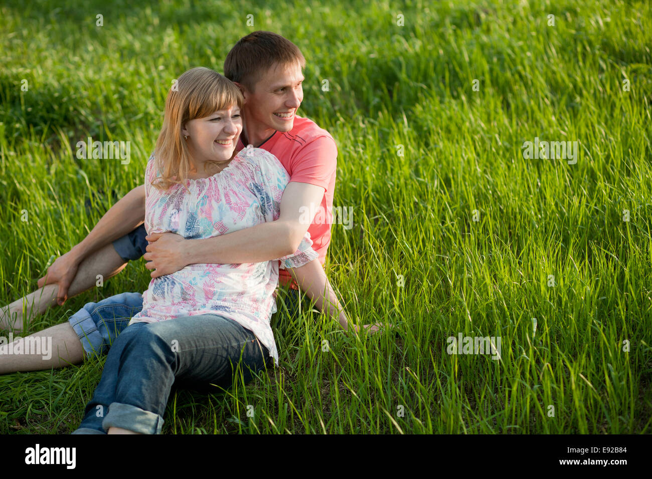 Happy couple lying on grass Stock Photo - Alamy