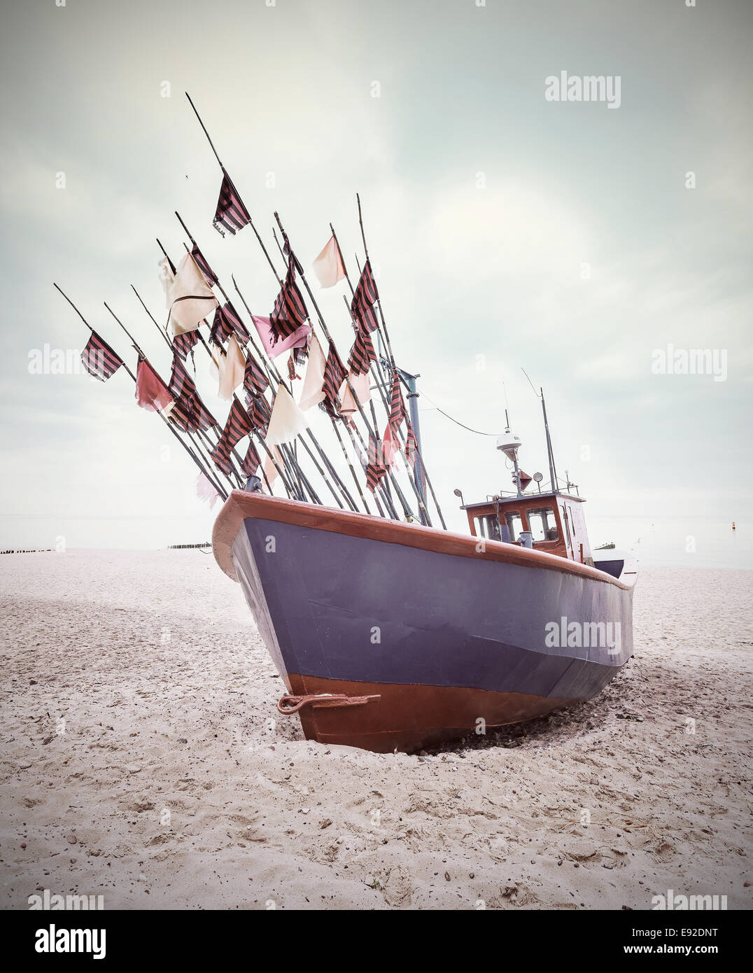 Small fishing boat on shore of the Baltic Sea, vintage retro style. Stock Photo