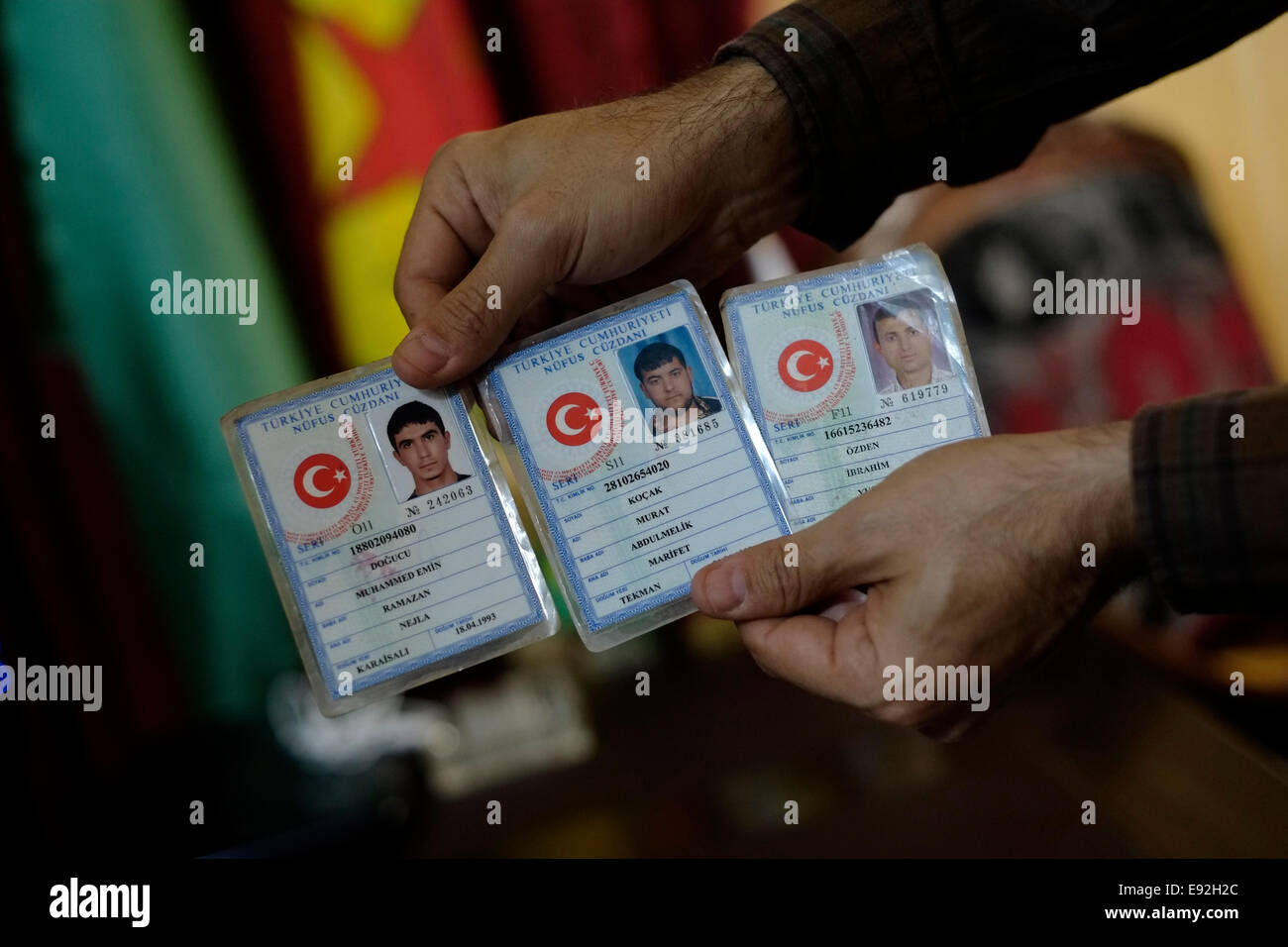 A fighter of the Kurdish People's Protection Units YPG holds collection of Turkish identity cards of captured ISIS ISIL or Daesh militants in the city of Qamishli or Qamishlo in Al Hasakah or Hassakeh district in northern Syria Stock Photo