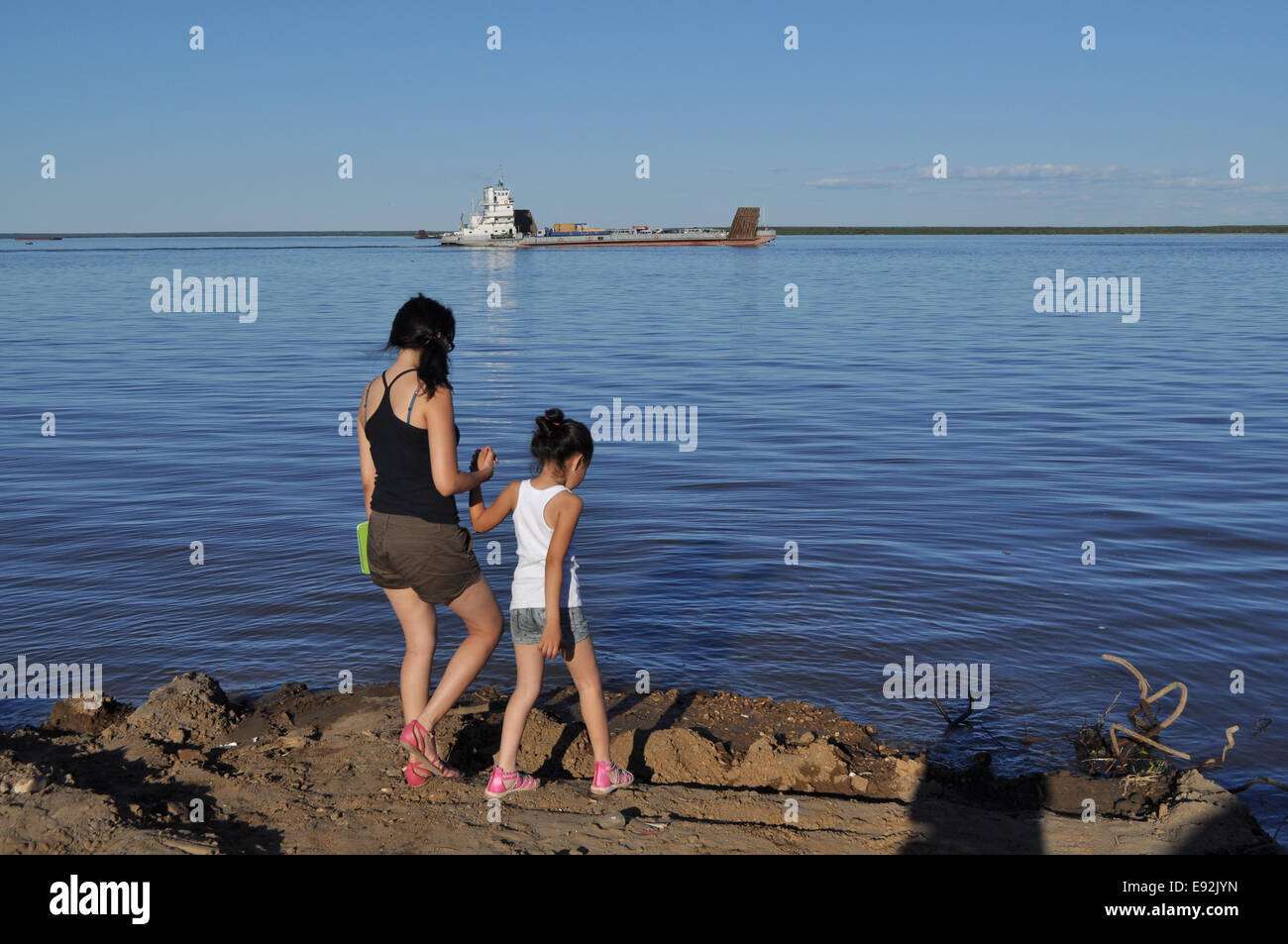 Ferry on the big river. Yakut rivers Lena and Aldan not have bridges. People are waiting for the ferry. Stock Photo