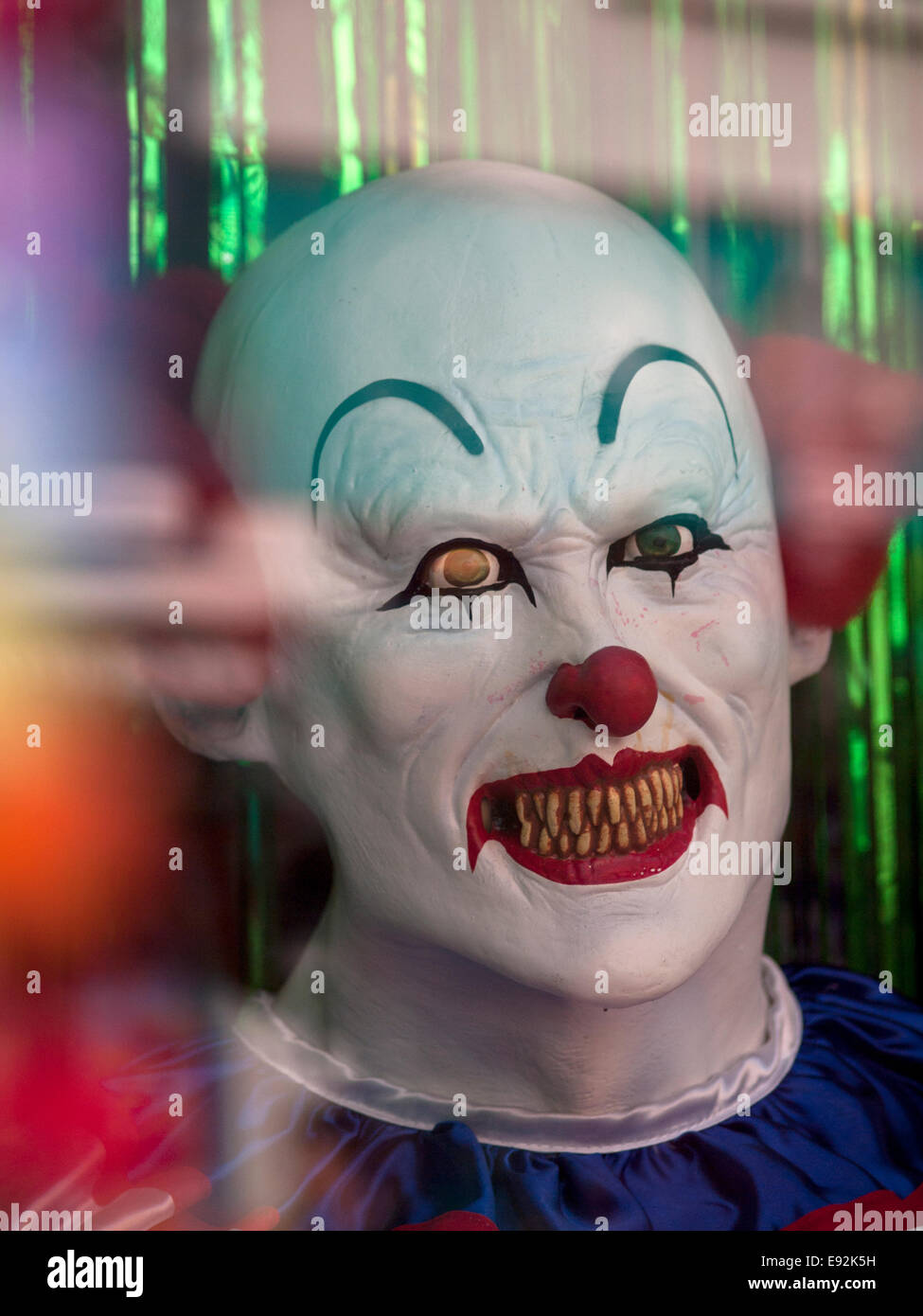 A scary clown mask in the window of a fancy dress shop in Brighton