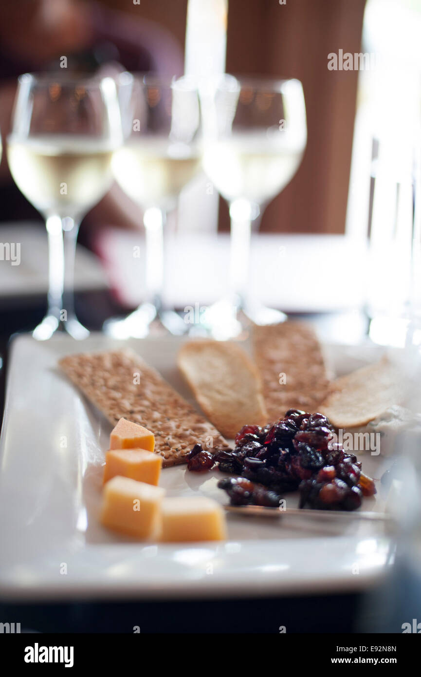 Plate of Appetizers with Glasses of White Wine in Background Stock Photo